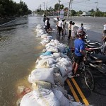 Residents stand along a flooded street in Thailand's Lopburi province